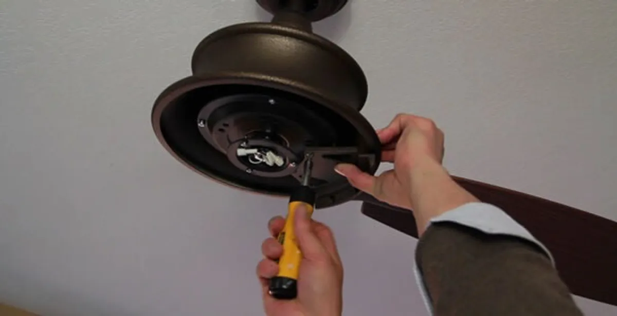 Electrician installing ceiling fan mounting bracket and fixture in Boca Raton, FL
