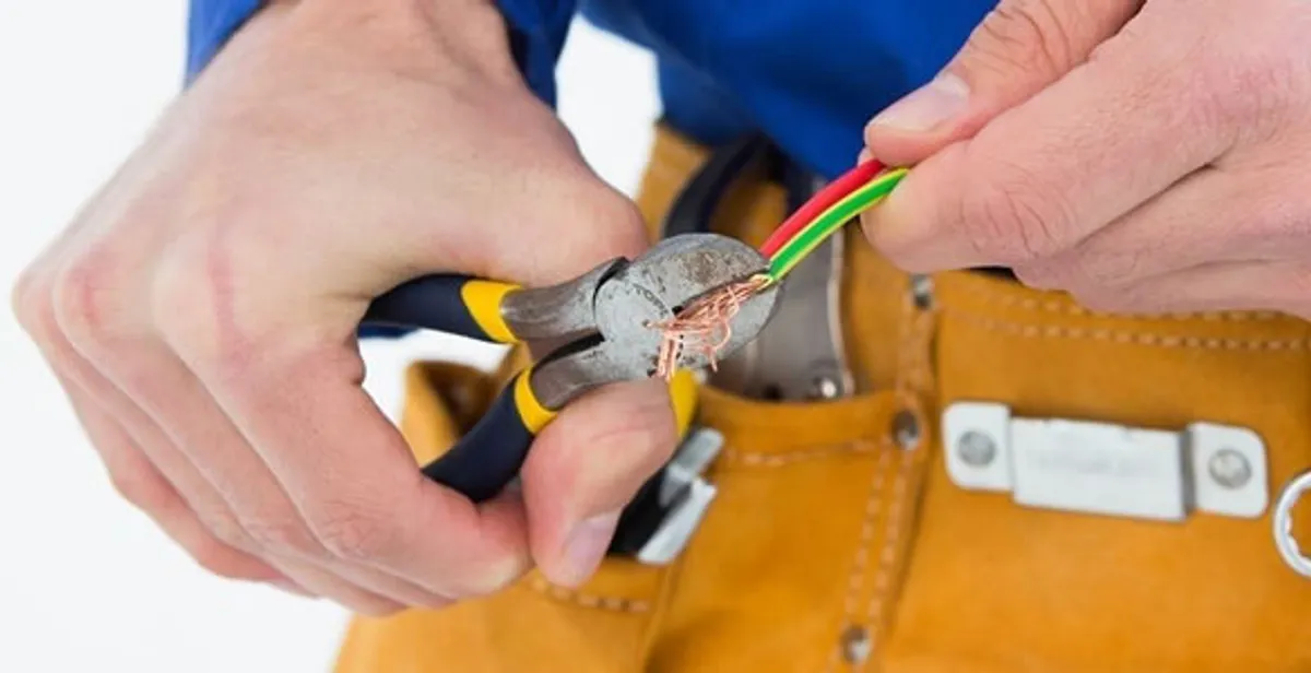 licensed electrician securing electrical wiring with professional tools during service work in Boca Raton, FL